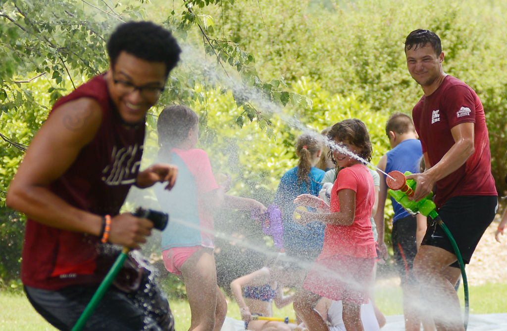 Camp counselors Kristof Cooney and Ian McCluskey have a hose fight during a water day